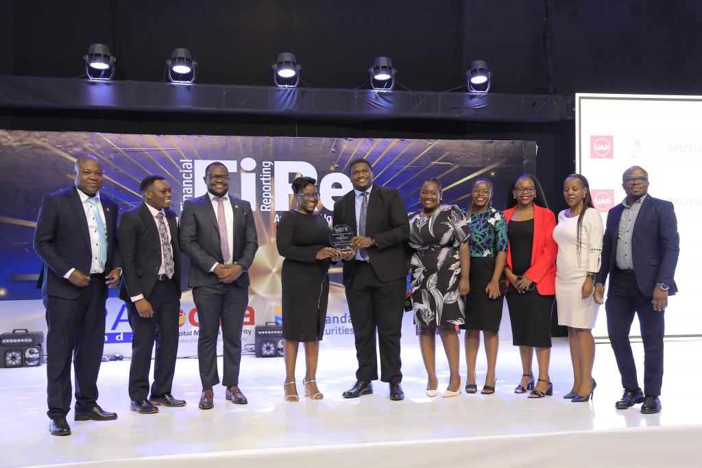 UAP Old Mutual Insurance (U) Limited representatives posing for a photograph with their award of Winner in financial reporting under the Insurance Companies – General Business category at the 2024 Financial Reporting (FiRe) awards.