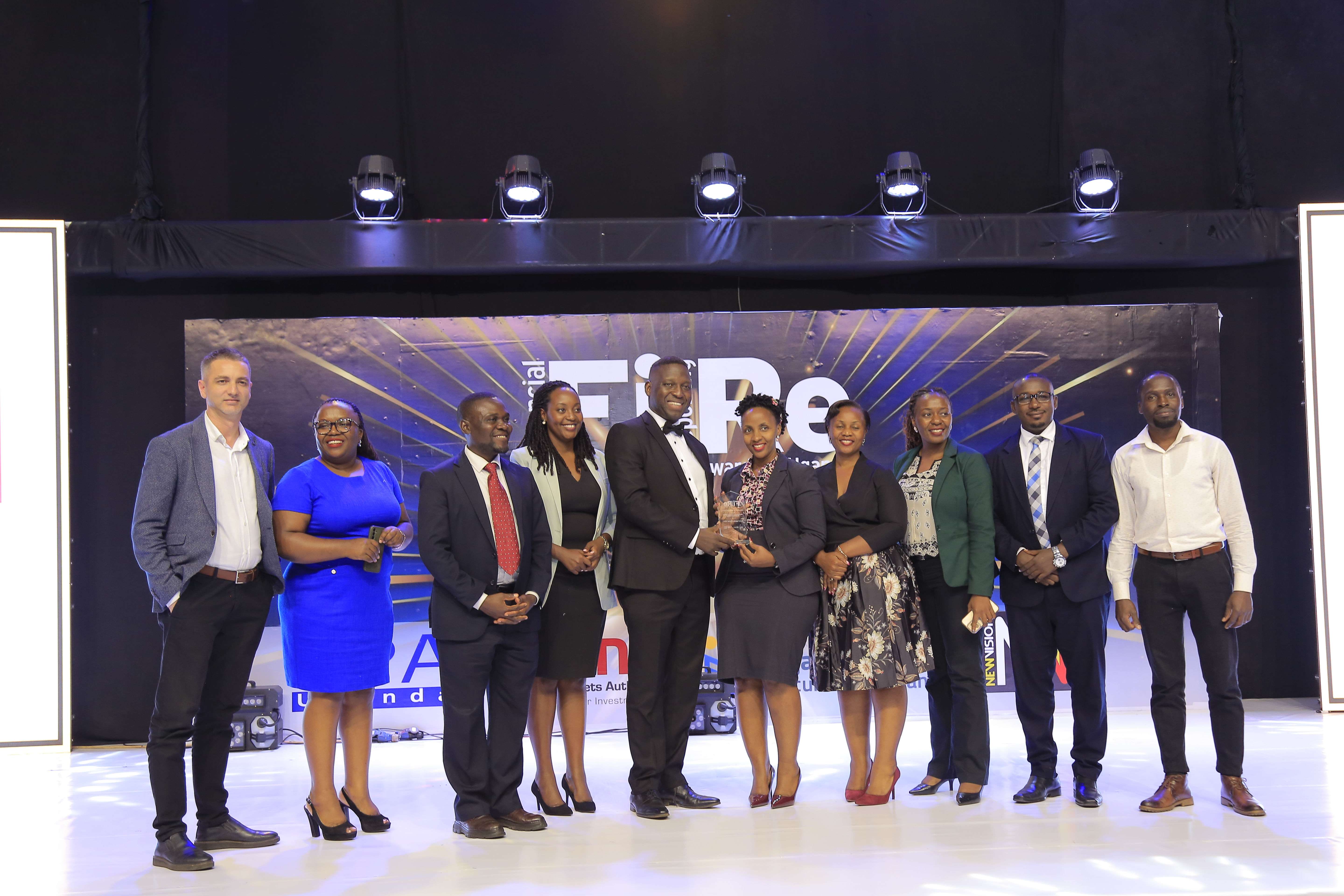 FINCA Uganda Limited (MDI) representatives posing for a photograph with their award of Winner in financial reporting under the microfinance deposit-taking institutions category at the 2024 Financial Reporting (FiRe) awards.