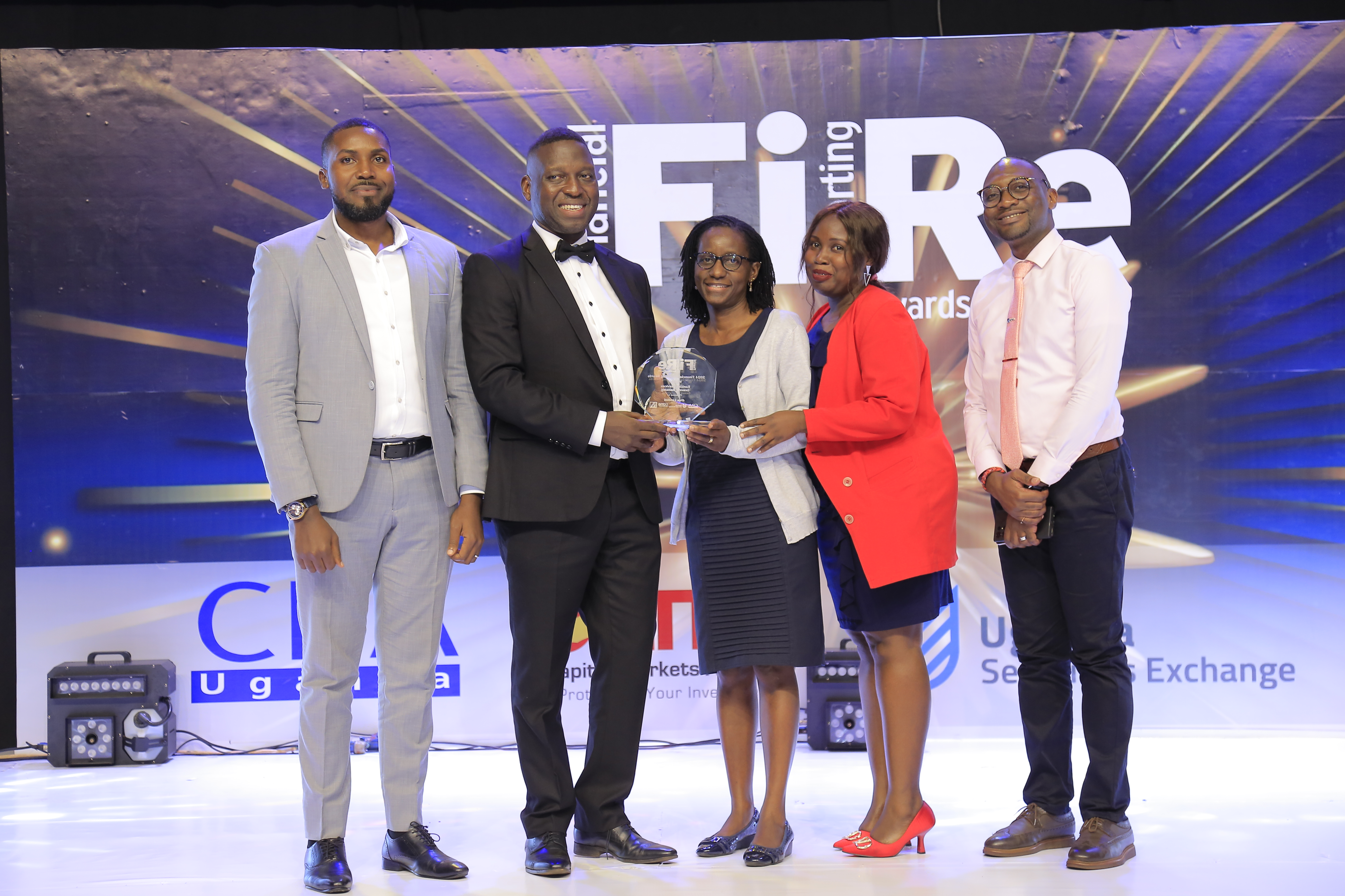 dfcu Limited representatives posing for a photograph with their award of Winner in financial reporting under the Banking Services – General Banking category at the 2024 Financial Reporting (FiRe) awards.