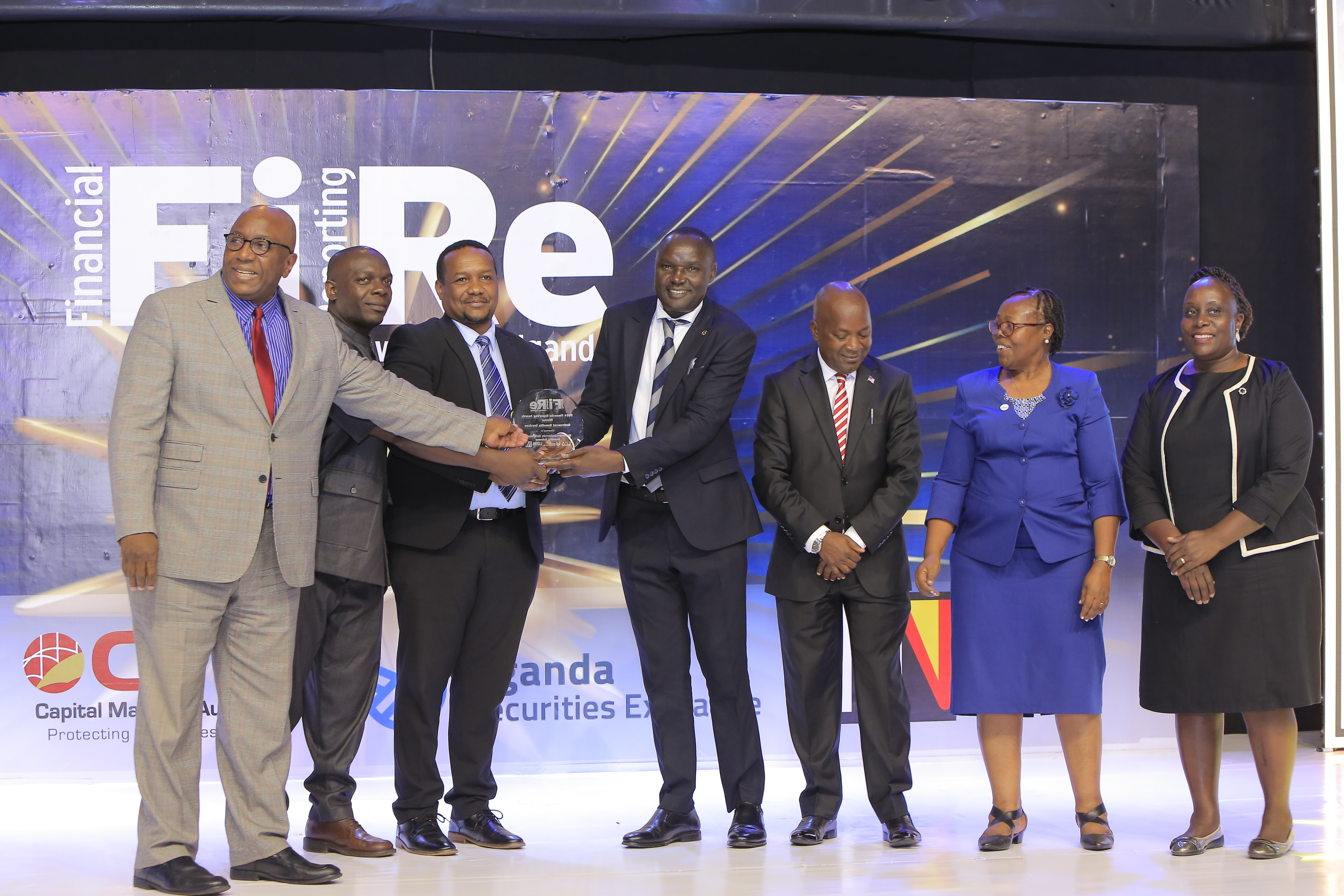 Makerere University Retirement Benefits Scheme representatives posing for a photograph with their award for Winner in financial reporting under the retirement benefits services category at the 2024 Financial Reporting (FiRe) awards ceremony held at Serena Hotel Kampala on 6 November 2024.