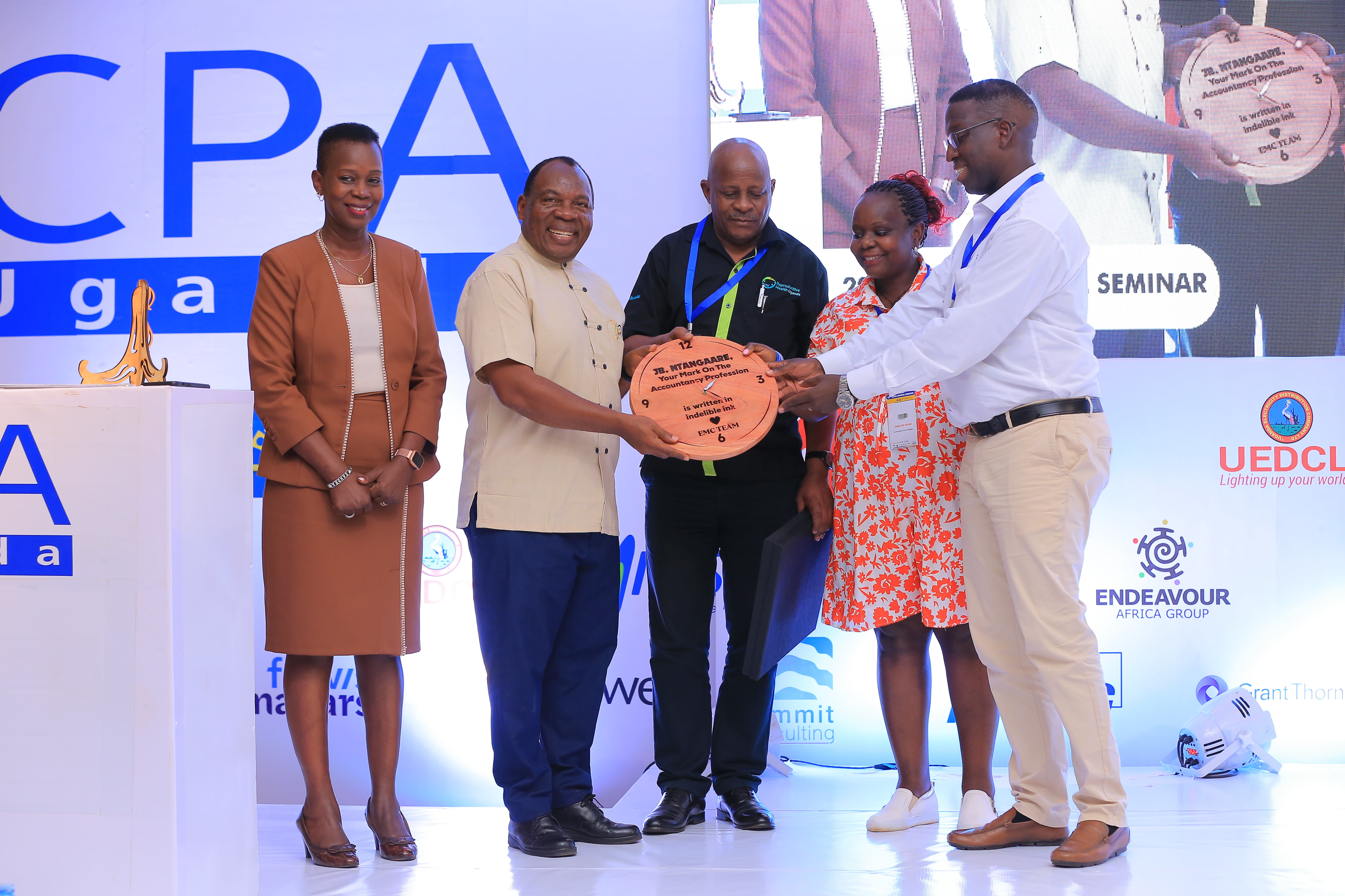 Mr. John Bosco Ntangaare, former Director of Education at ICPAU(2nd L), receiving a gift from members of the Events Management Committee in recognition of his 26 years of service at ICPAU.