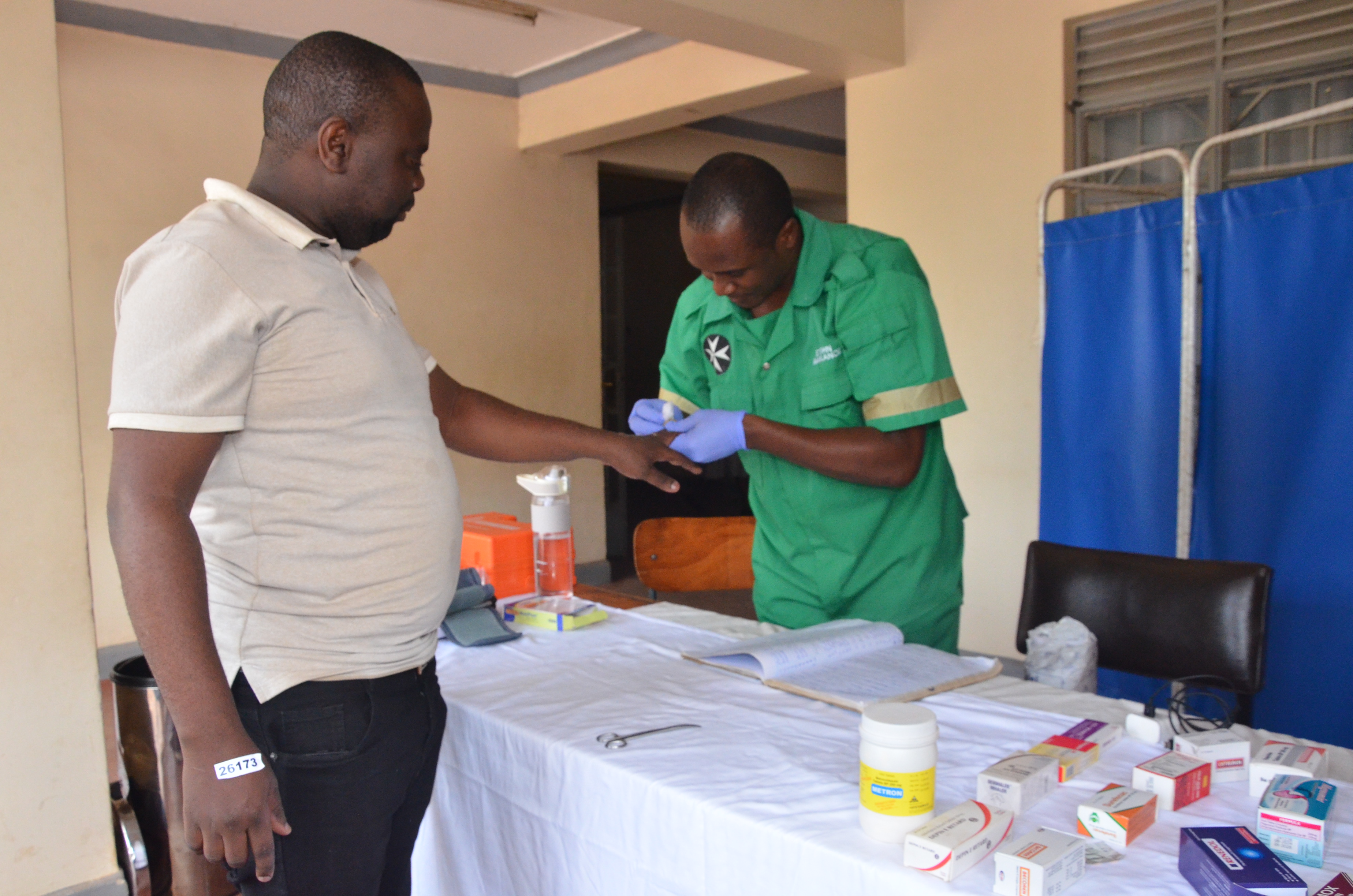 A nurse from St John Ambulance dressing a wound of a student at the Kampala examinations centre before their exam.