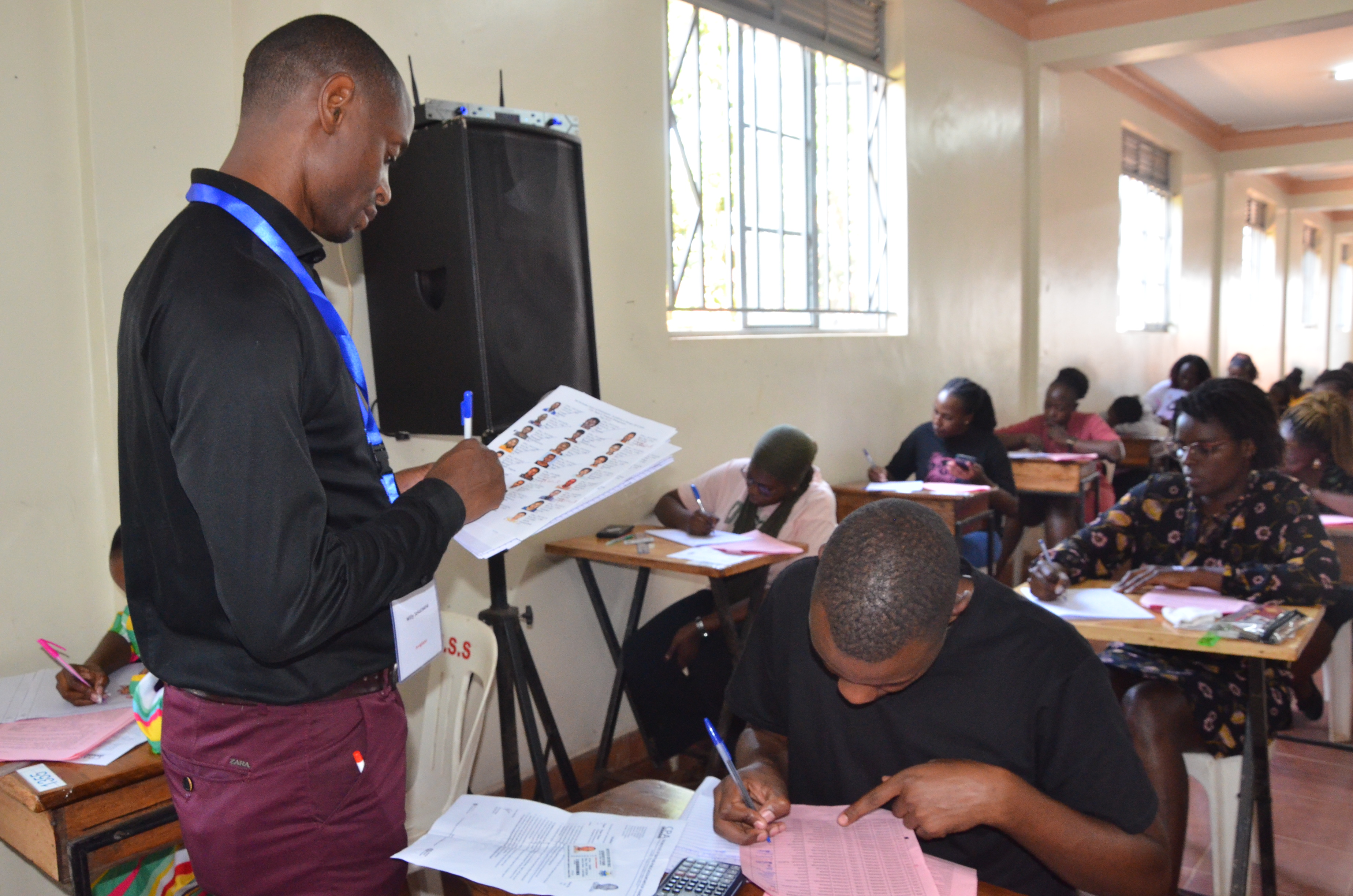 An invigilator roll calling and registering students during the examinations at the Kampala centre.