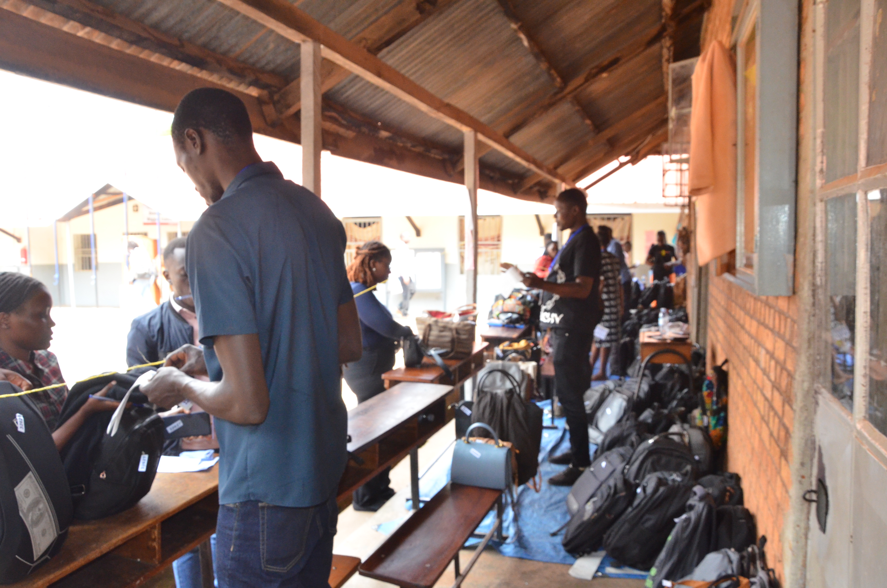 Officials at the student luggage hundling area receiving luggage from candidates before the exams at the Kampala centre.