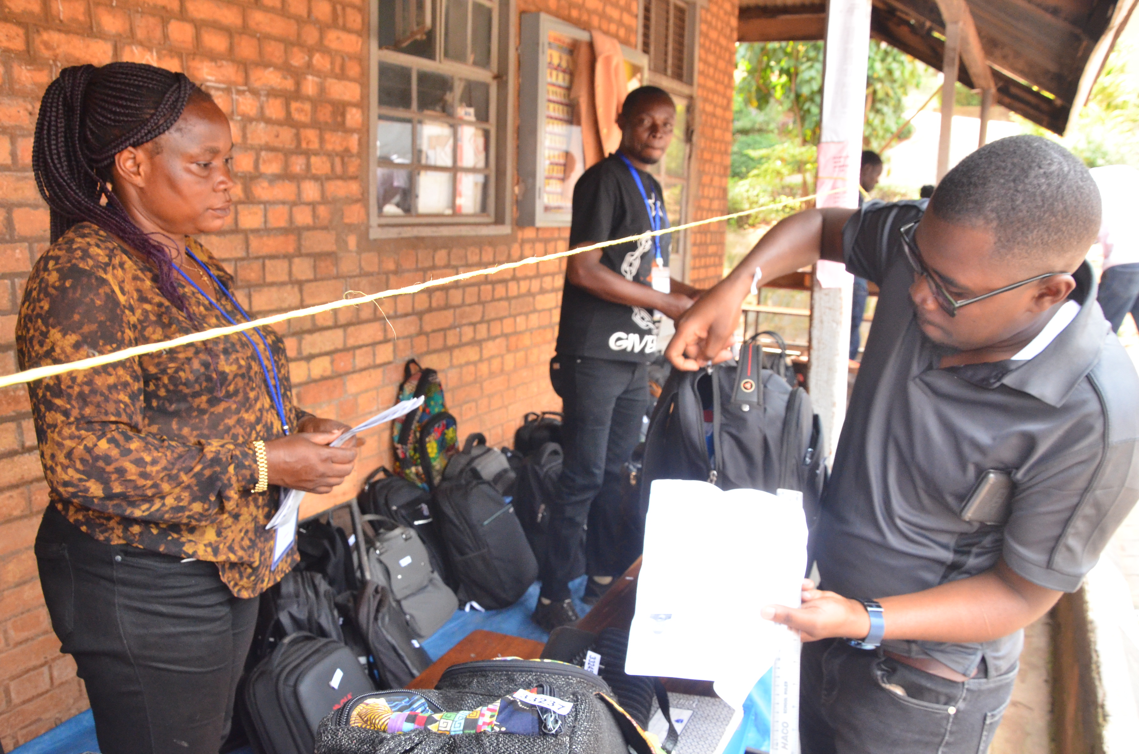 Officials at the student luggage hundling area receiving luggage from one of the candidates before the exams.