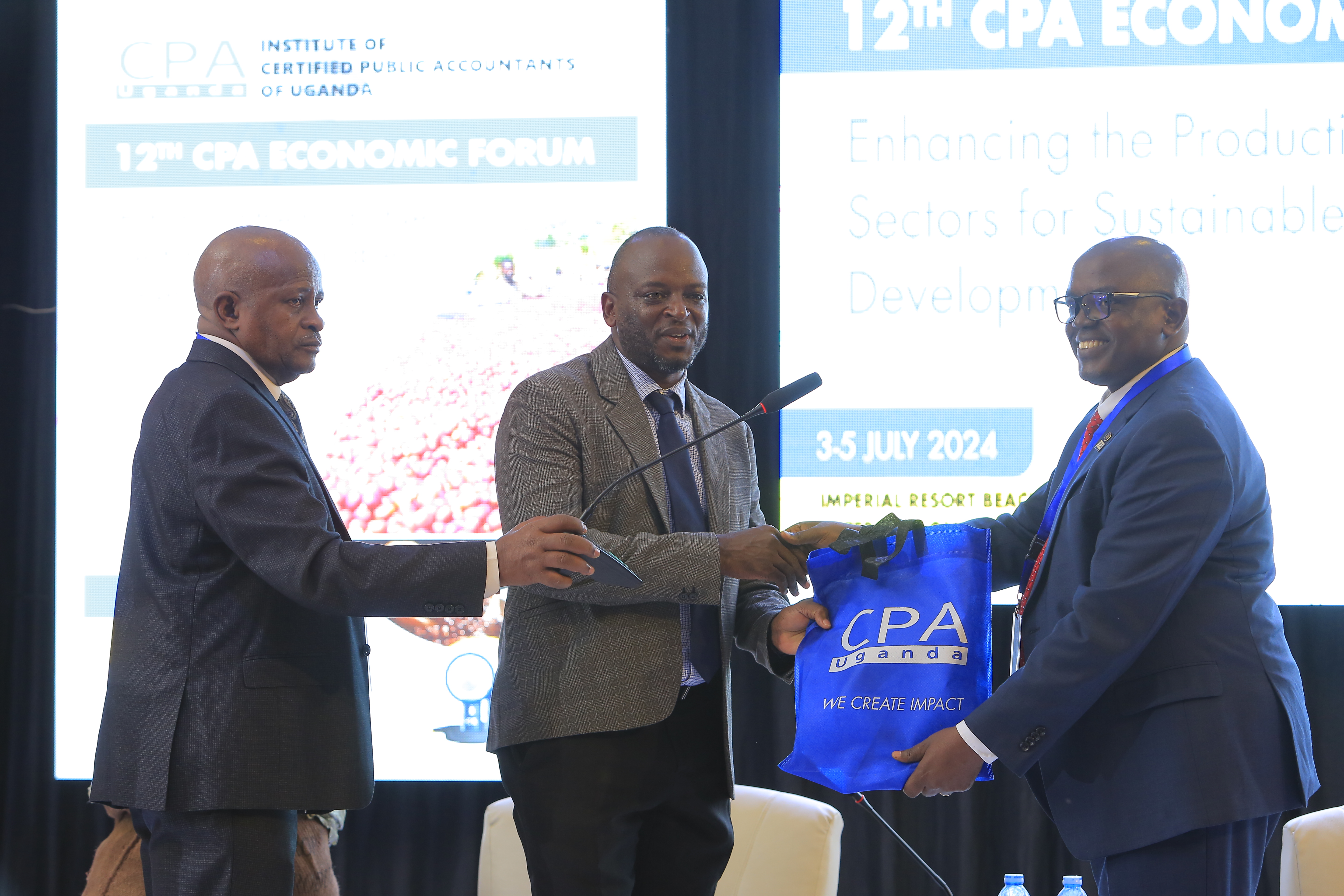 One of the Silver sponsors, Bank of Uganda (C) receiving a token of appreciation from ICPAU’s former President CPA Constant Mayende at the 12th CPA Economic Forum.