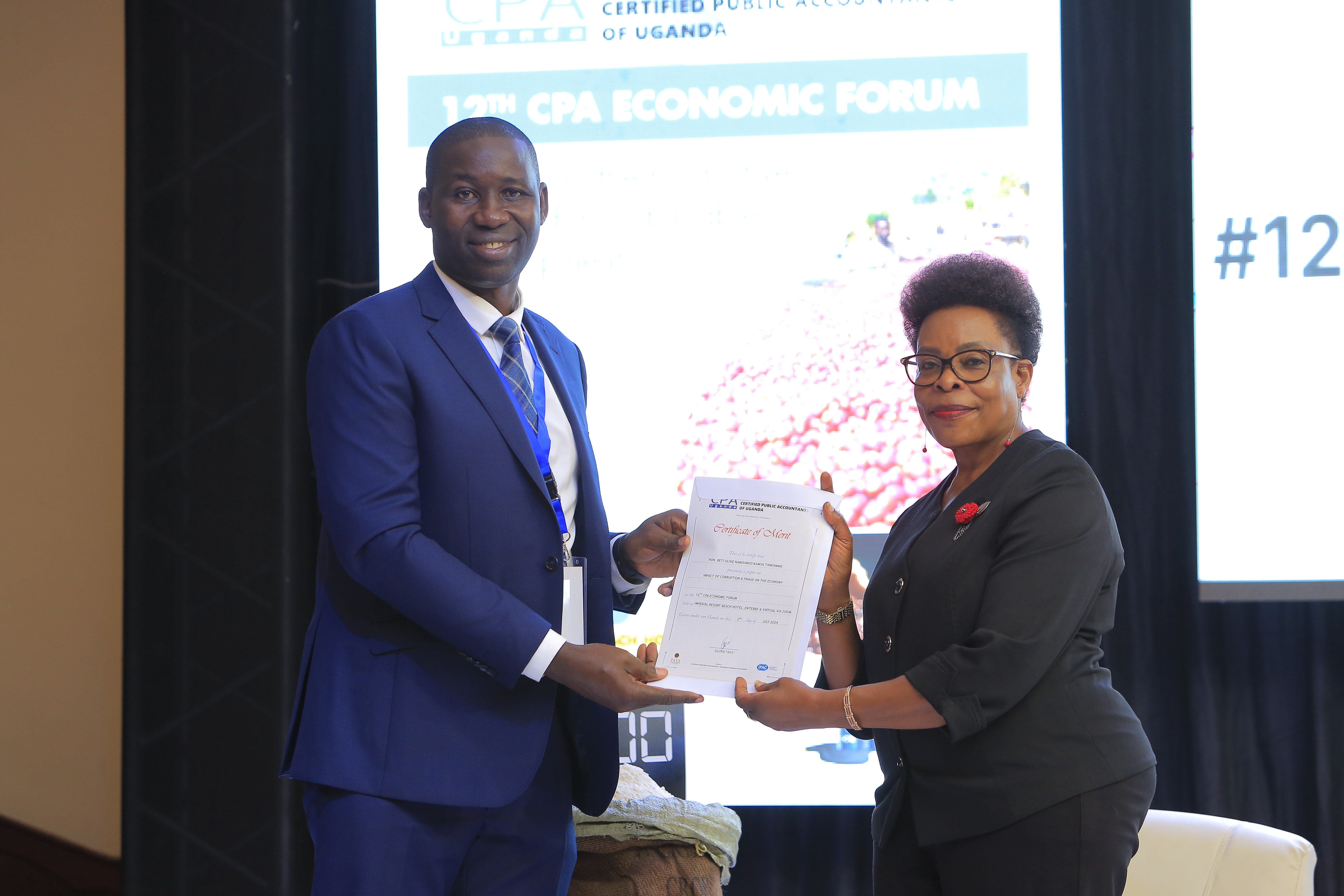 Beti Kamya Turwomwe, Inspector General of Government of Uganda (R) receiving a certificate of merit from CPA Geofrey Byamugisha (L) at the 12th Economic Forum.