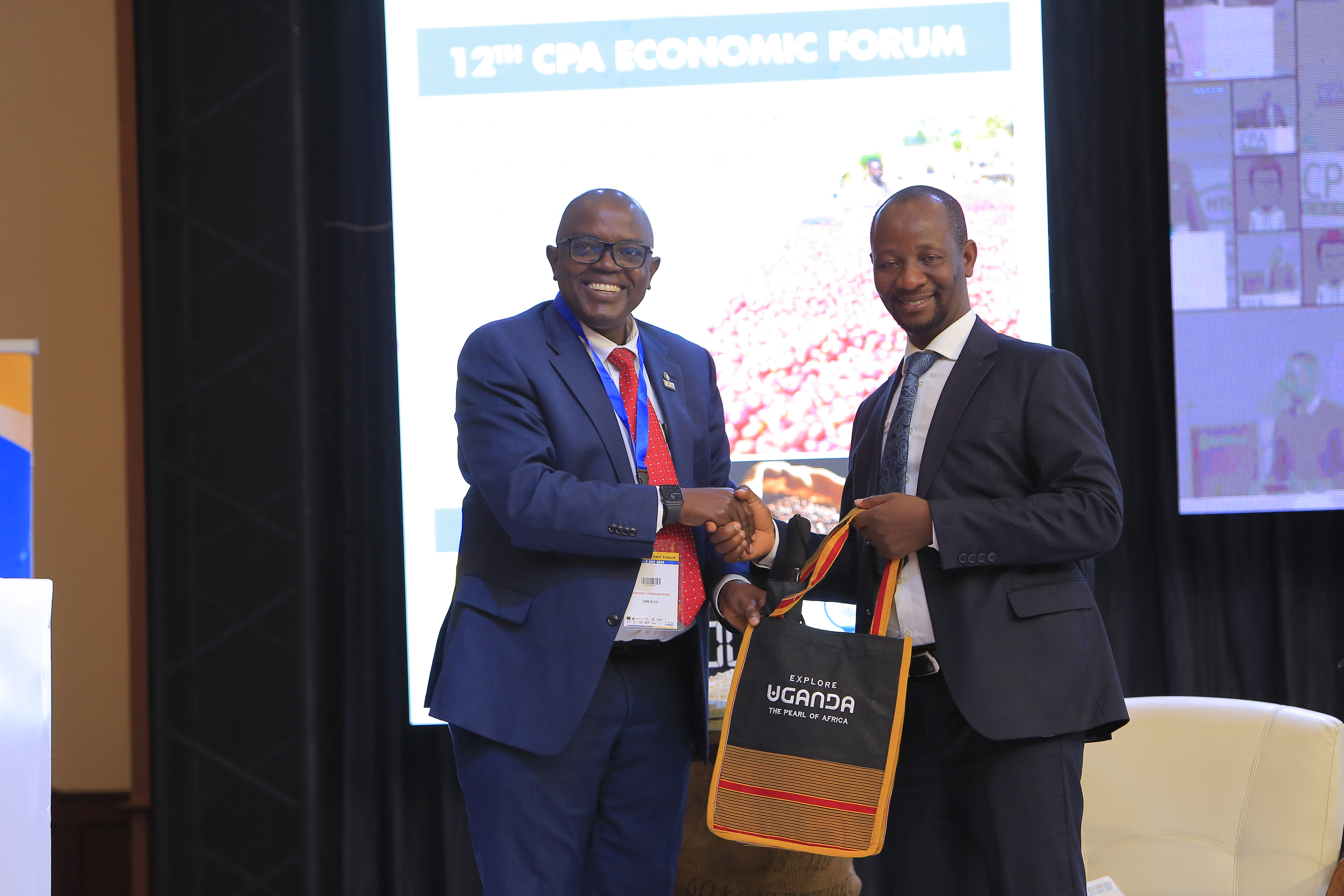 Hon. Ibrahim Ssemujju Nganda, Member of Parliament of Uganda for Kira Municipality(L), receiving a token of appreciation from ICPAU’s former President CPA Constant Mayende (R) at the 12th Economic Forum.