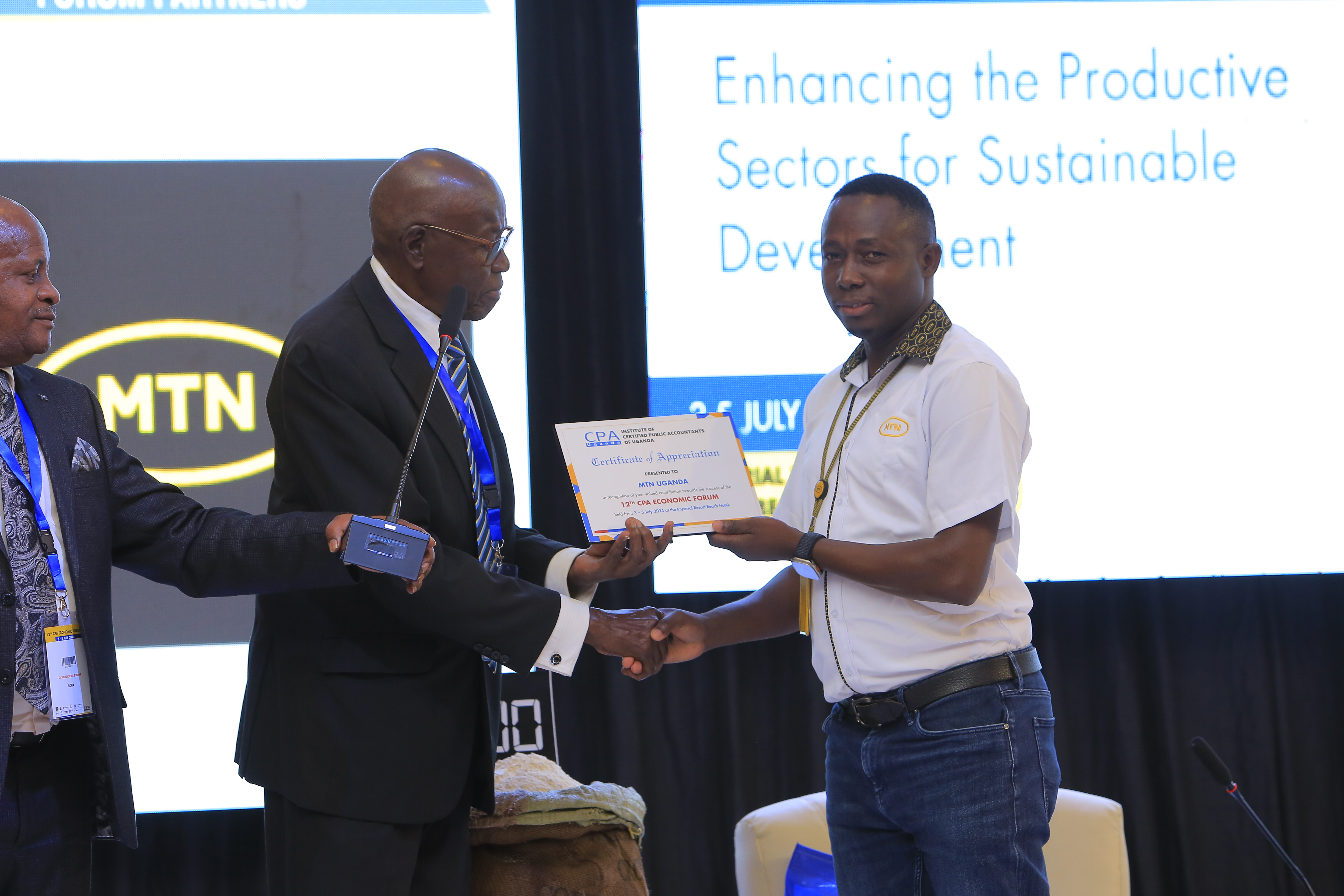 The Gold sponsor, MTN Uganda (R)receiving a certificate of merit for ICPAU’s past President CPA George William Egaddu (L) at the 12th Economic Forum
